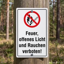 Das Bild zeigt ein Schild, das an einem Baumstamm...