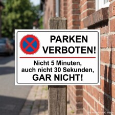 Das Bild zeigt ein Schild mit der Aufschrift „PARKEN VERBOTEN!“ in großen, schwarzen Buchstaben auf weißem Hintergrund. Unterhalb steht der Hinweis, dass das Parken weder für 5 Minuten noch für 30 Sekunden erlaubt ist, und das Ganze wird durch ein rotes Verbotssymbol ergänzt; das Schild ist an einem Holzpfahl befestigt und befindet sich in einer städtischen Umgebung.