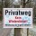 Das Bild zeigt ein Schild, das auf einem Holzpfosten befestigt ist und den Hinweis Privatweg sowie Kein Winterdienst! in großen, auffälligen Buchstaben enthält. Es warnt davor, den Weg in der Winterzeit auf eigene Gefahr zu benutzen, und ist in einem ländlichen Umfeld aufgestellt, wo der Weg von Bäumen umgeben ist.