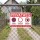 Das Bild zeigt ein Schild mit dem Text PRIVATWEG, das an einem Zaun befestigt ist. Es weist darauf hin, dass Parken, Durchfahren und Betreten des Weges verboten sind und ist für die Nutzung nur durch Anwohner gedacht.