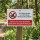 Das Bild zeigt ein Schild, das in einem Waldgebiet aufgestellt ist. Es weist darauf hin, dass Hunde willkommen sind, jedoch deren Hinterlassenschaften nicht toleriert werden, und fordert Hundebesitzer auf, die Hinterlassenschaften ihrer Tiere einzusammeln.