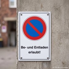 Das Bild zeigt ein Schild, das an einer Wand befestigt...