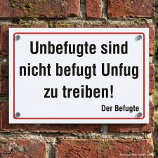 Das Bild zeigt ein Schild, das an einer Ziegelmauer befestigt ist. Der Text auf dem Schild warnt, dass Unbefugte nicht erlaubt sind, Unfug zu treiben, und es ist in einer klaren, großen Schrift verfasst, um die Botschaft deutlich zu machen.