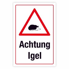 Das Bild zeigt ein Warnschild mit einem roten Dreieck, das einen Igel abbildet, und dem Schriftzug „Achtung Igel“ darunter. Das Schild steht am Straßenrand und weist Autofahrer darauf hin, dass in dieser Gegend Igel häufig über die Straße laufen könnten.