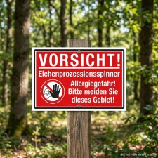 Das Bild zeigt ein rotes Warnschild mit der Aufschrift VORSICHT! Eichenprozessionsspinner Allergiegefahr! und einem Symbol, das eine Hand vor einem Gesicht zeigt. Das Schild steht in einem Waldgebiet und weist darauf hin, dass Menschen dieses Gebiet meiden sollten, um allergischen Reaktionen vorzubeugen.