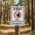 Das Bild zeigt ein Warnschild, das auf die Allergiegefahr durch Kiefernprozessionsspinner hinweist. Es ist in einem Wald aufgestellt und enthält ein rotes Stoppsymbol sowie eine Hand, die signalisiert, dass man vorsichtig sein soll.