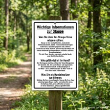 Das Bild zeigt ein Informationsschild im Wald, das...