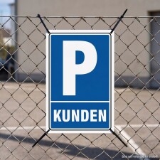 Das Bild zeigt ein Schild mit dem weißen Buchstaben P auf blauem Hintergrund, das den Hinweis KUNDEN in großen, weißen Buchstaben darunter trägt. Dieses Schild ist an einem Zaun befestigt und kennzeichnet einen Parkplatz, der ausschließlich für Kunden vorgesehen ist.